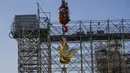 Replika ayam emas diangkat ke puncak menara katedral Notre Dame sebagai bagian dari pekerjaan restorasi di Paris, Sabtu (16/12/2023). (AP Photo/Michel Euler)