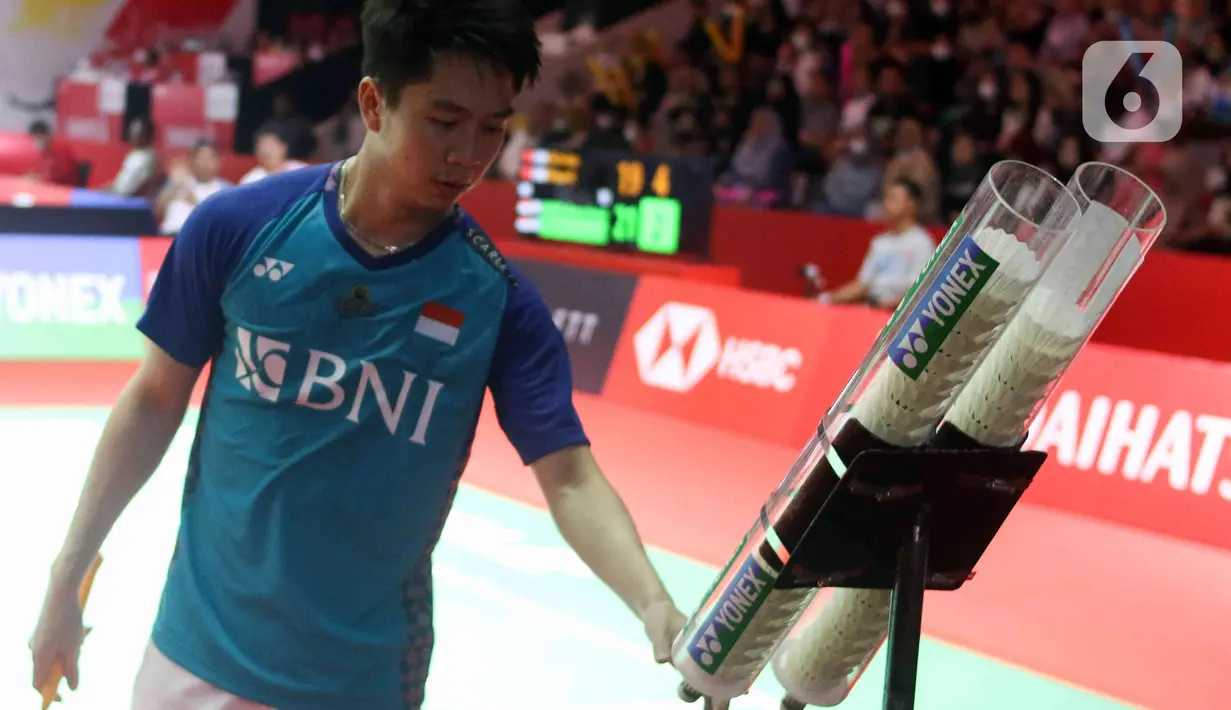 Pebulu tangkis ganda putra Indonesia Kevin Sanjaya mengambil kok saat bertanding bersama Marcus Gideon melawan pebulu tangkis ganda putra China Liu Yu Chen/Ou Xuan Yi pada babak 16 besar turnamen Daihatsu Indonesia Masters 2023 di Istora Senayan, Jakarta, Kamis (26/1/2023). The Minions gagal lolos ke babak selanjutnya karena memutuskan untuk mundur atau retired pada set ketiga akibat cedera yang dialami Marcus Gideon saat ganda China unggul dengan skor 19 - 21, 21-8, dan 11-6. (Liputa6.com/Herman Zakharia)