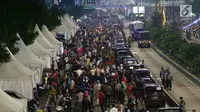 Warga memadati malam pergantian tahun di Jalan MH Thamrin, Jakarta, Minggu (31/12). Pemprov DKI Jakarta memberlakukan car free night di Jalan Sudirman hingga Thamrin. (Liputan6.com/Angga Yuniar)