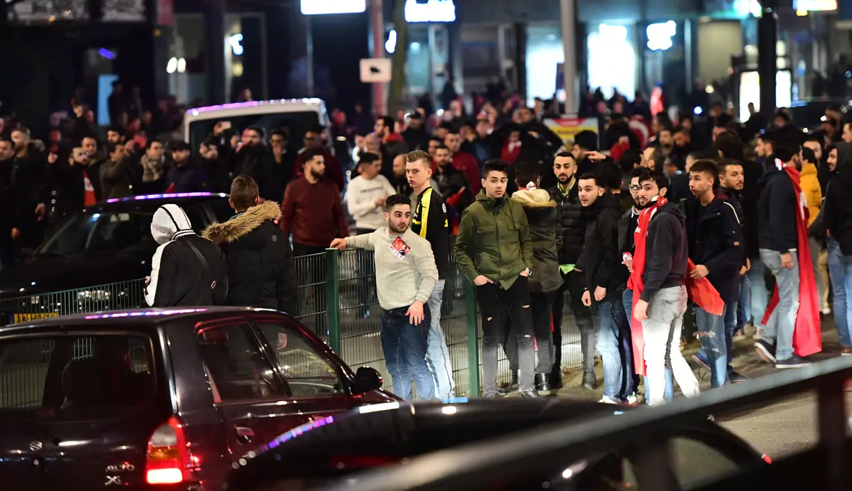 Sejumlah warga Turki berkumpul menggelar aksi protes di Rotterdam, Belanda (11/3). Setelah Belanda melarang kedatangan Menlu Turki, Erdogan pun berjanji untuk melakukan pembalasan terhadap penerbangan diplomatik Belanda. (AFP/Emmanuel Dunand)
