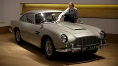 Seorang staf berpose dengan Aston Martin DB5 yang digunakan dalam film James Bond GoldenEye tahun 1995 di rumah lelang Bonham, London, Selasa (19/6). Mobil legendaris yang dikemudikan aktor Pierce Brosnan itu bakal dilelang pemiliknya. (AP/Matt Dunham)