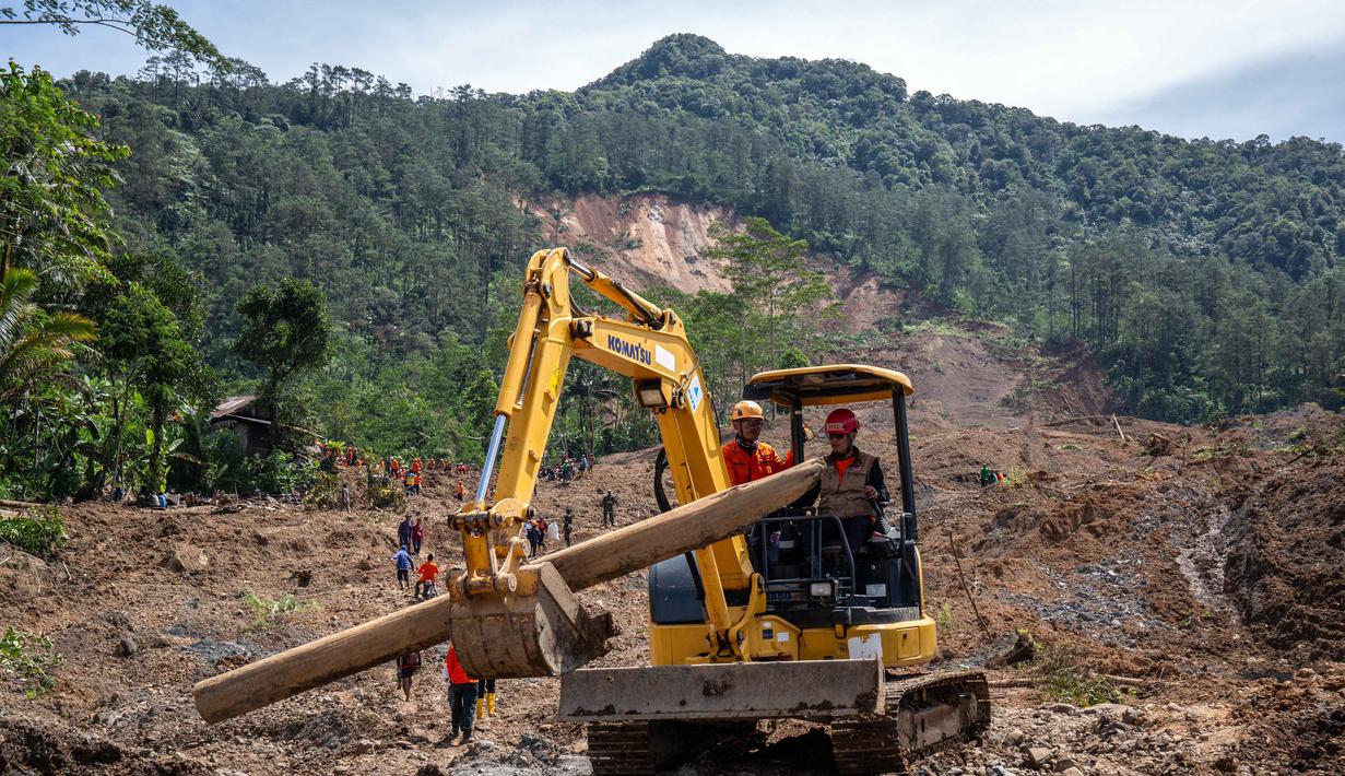 Sebelumnya, 0perasi pencarian korban sempat tertunda akibat pergerakan tanah yang terus terjadi di area longsoran. Tampak dalam foto, alat berat mengangkat batang kayu selama operasi penyelamatan di lokasi longsor di Desa Situkung, Banjarnegara, Jawa Tengah, pada Rabu 19 November 2025. (DEVI RAHMAN/AFP)