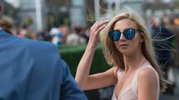 Seorang wanita cantik menghadiri pembukaan pacuan kuda Aintree di Liverpool, Inggris, Kamis (7/4/2016). Acara yang digelar setiap tahun ini dihadiri para bangsawan dan kaum menengah. (Oli SCARFF/AFP)
