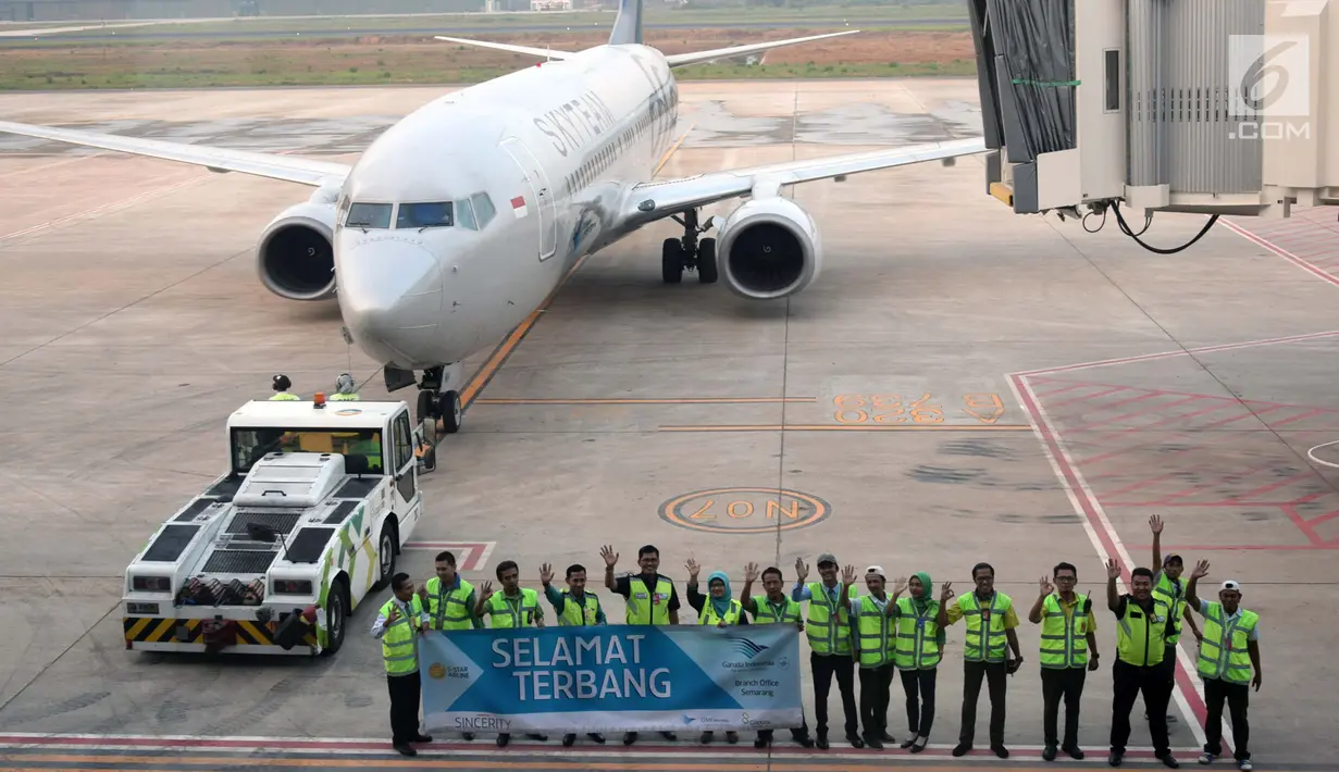 Petugas membentangkan spanduk "Selamat Terbang" di landasan pacu terminal baru Bandara Ahmad Yani Semarang, Rabu (6/6). Terminal ini sudah mulai beroperasi ditandai dengan maskapai penerbangan pertama SKYTEAM Garuda Indonesia. (Liputan6.com/Gholib)