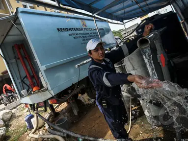 Petugas menunjukkan air bersih dari hasil sulingan di Rusun Muara Baru, Jakarta, Rabu (22/4/2015). Minimnya air bersih di rusun tersebut membuat kementerian pekerja umum menyediakan alat penyulingan air . (Liputan6.com/Faizal Fanani)