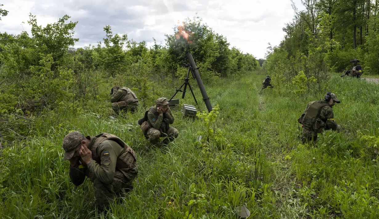 Prajurit Ukraina didampingi anggota legiun asing menembakkan mortir ke posisi Rusia di wilayah Kharkiv, Ukraina, 17 Mei 2022. (AP Photo/Bernat Armangue)