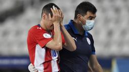 Pemain Paraguay, Miguel Almiron, mengangis saat berjalan keluar lapangan usai mendapatkan cedera saat melawan Uruguay pada laga Copa America 2021 di Stadion Nilton Santos, Rio de janiero, Brasil, Senin (28/6/2021). (Foto: AFP/Mauro Pimentel)