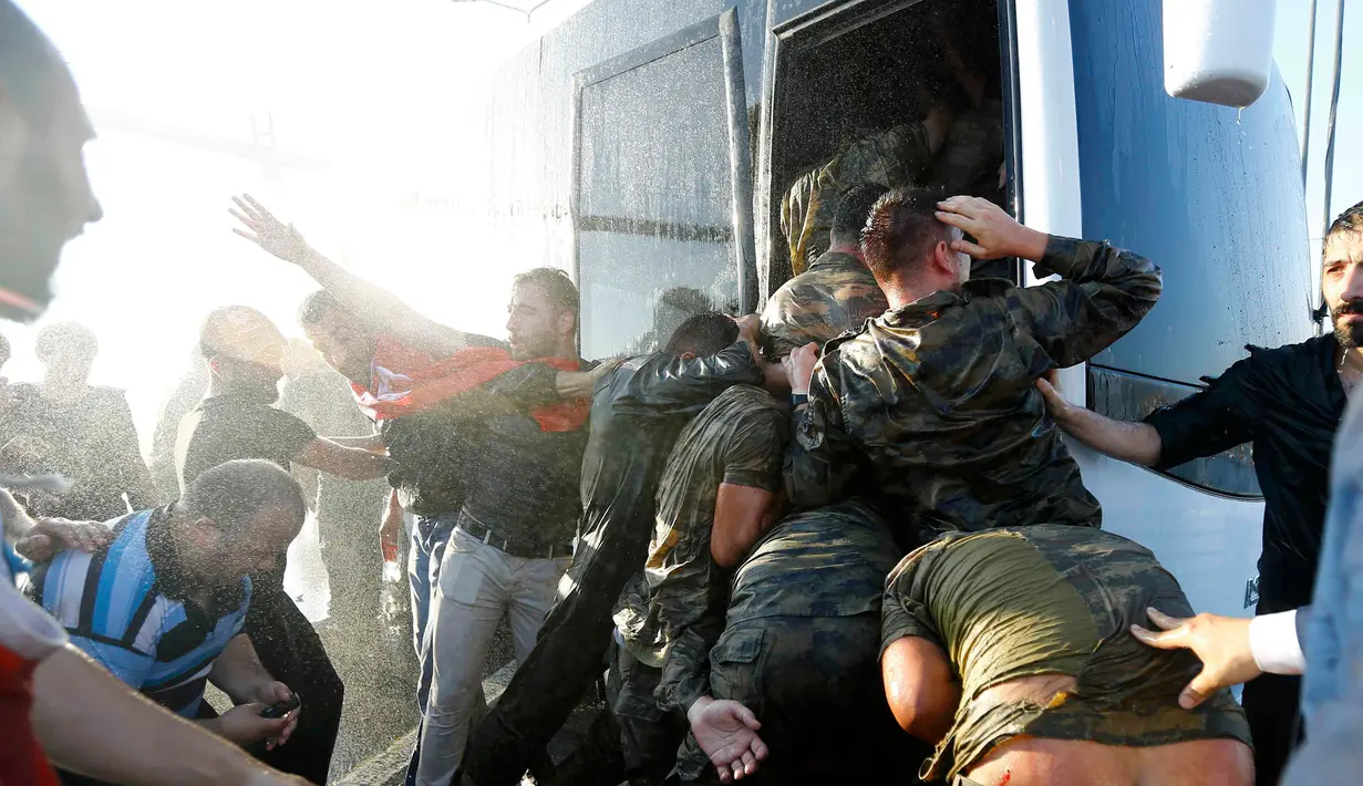 Warga membawa kayu untuk mengarahkan pukuannya ke para tentara yang masuk kedalam bus di Jembatan Bosphorus, Istanbul , Turki, (16/7).Warga Turki mengamuk atas kudeta yang dilakukan militer Turki. (REUTERS / Murad Sezer)