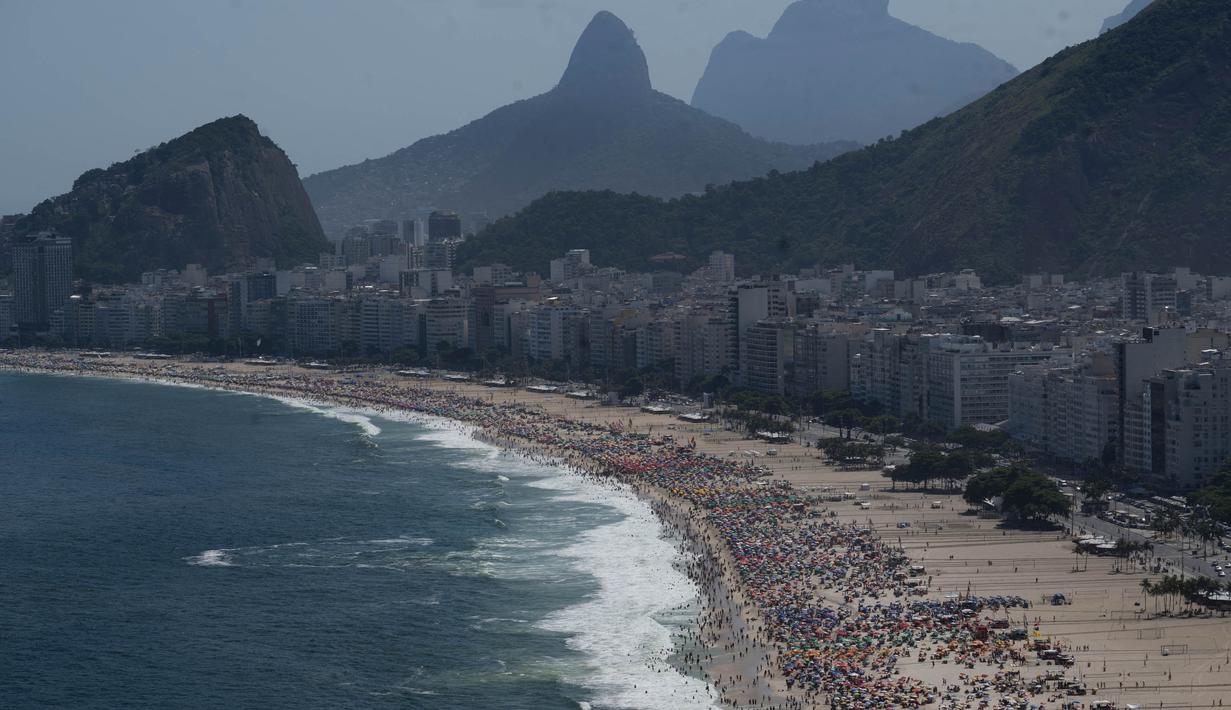 Orang-orang menikmati hari di pantai Copacabana di Rio de Janeiro, Brasil, pada 16 Februari 2025. (Pablo PORCIUNCULA/AFP)