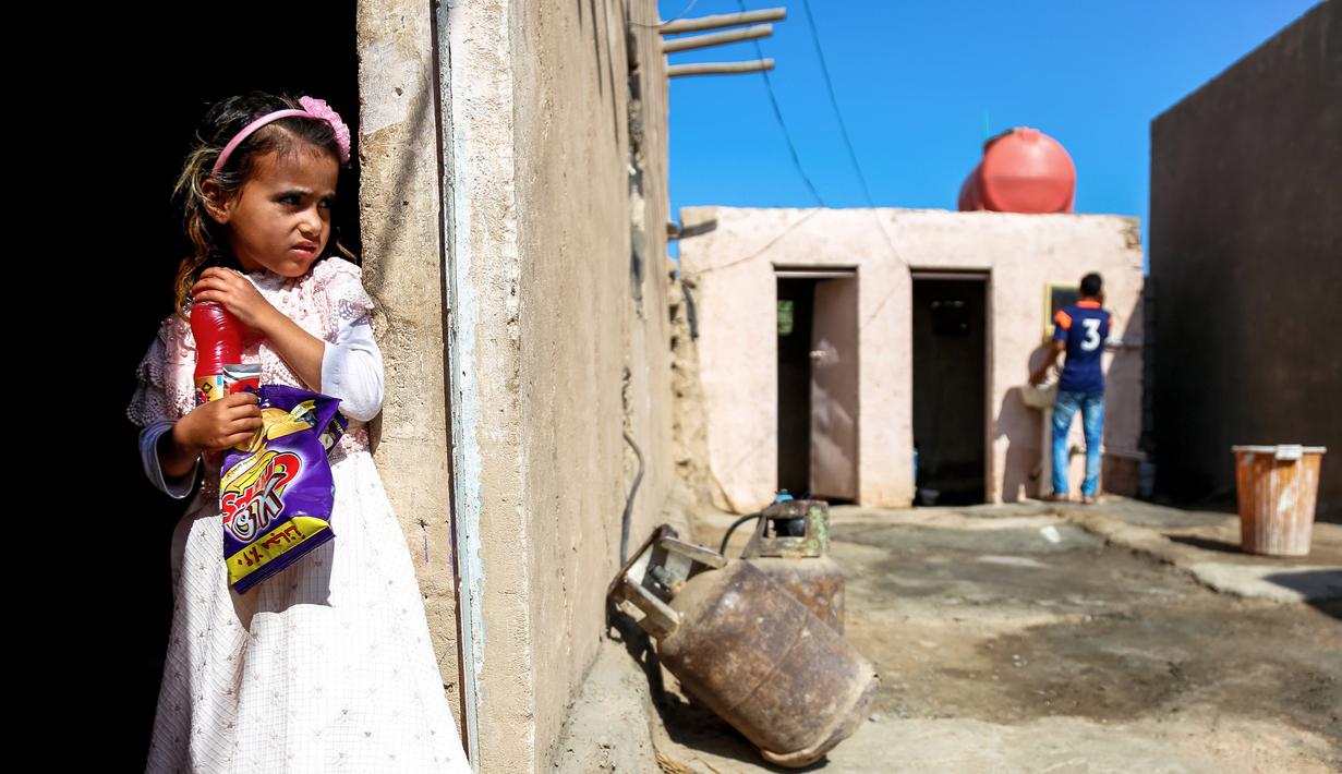Houra berada di rumahnya di desa Wahed Haziran, Provinsi Diwaniya, Irak, (17/3). Bocah empat tahun ini kini tak lagi bersekolah karena terus menerima cemoohan dari teman-temannya. (AFP Photo/Haidar Hamdani)