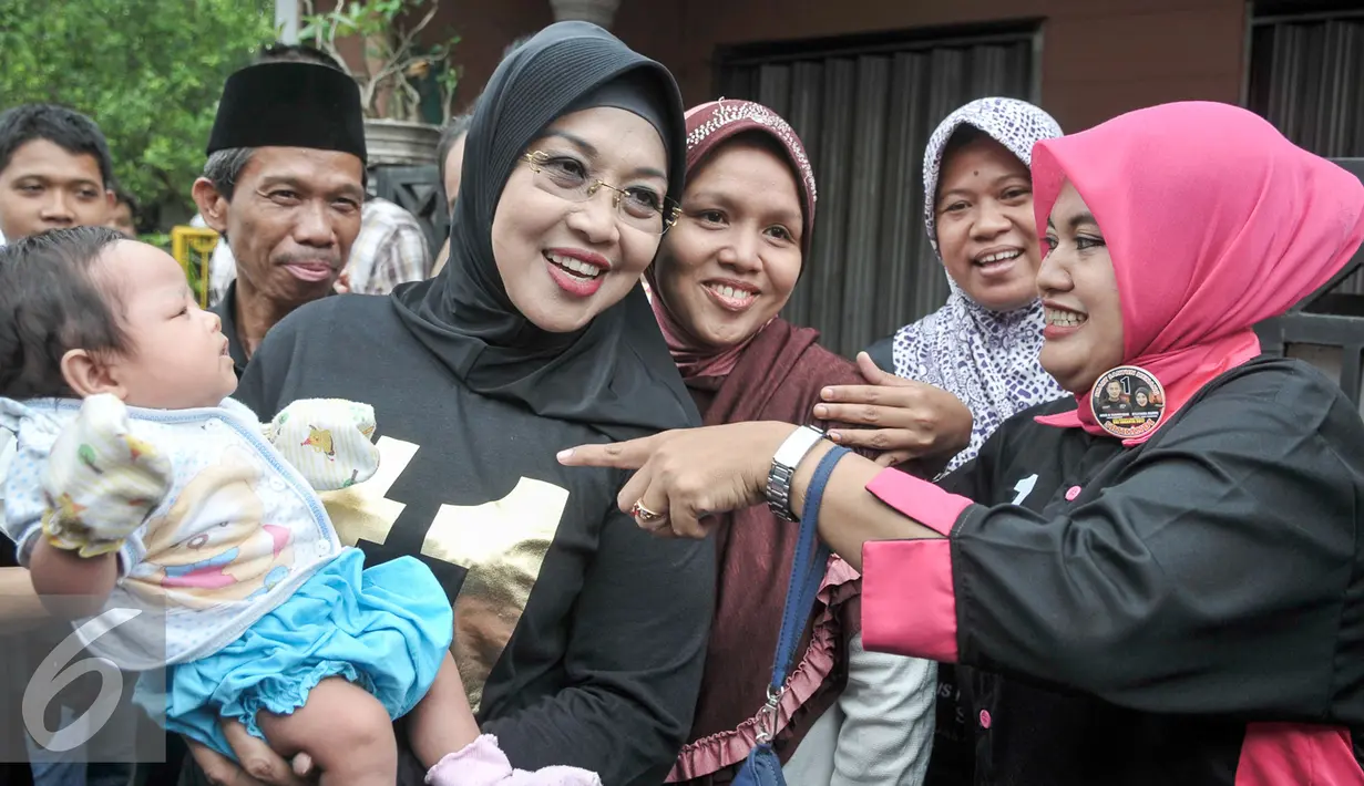 Calon Wakil Gubernur DKI Sylviana Murni mengendong bayi warga saat gerilya ke Jalan Famili, Jagakarsa, Jakarta Selatan, Kamis (5/1). Selain meminta dukungan, Sylvi juga memaparkan visi misinya bila terpilih nanti. (Liputan6.com/Yoppy Renato)