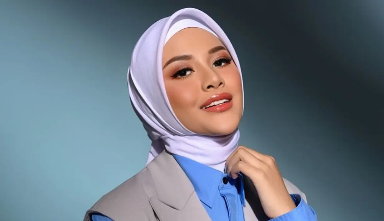 Yang kali ini bisa jadi inspirasi untuk Sahabat FIMELA yang kerja kantoran. Dengan kemeja biru polos, Aurelie Hermansyah menambahkan vest abu-abu dan memadukannya dengan jilbab putih polos. Foto: Instagram.