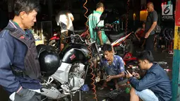 Montir mengecek kondisi kendaraan di bengkel sepeda motor di Jakarta, Jumat (16/6). Musim mudik membawa keberkahan tersendiri bagi bengkel service mobil dan motor. (Liputan6.com/Immanuel Antonius)