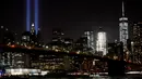 Kilauan lampu terlihat di langit kota Manhattan dari Brooklyn Bridge Park jelang peringatan 15 tahun tragedi runtuhnya Gedung WTC 11 September 2001 di New York, Amerika Serikat, Sabtu (10/9). (REUTERS/Mark Kauzlarich)