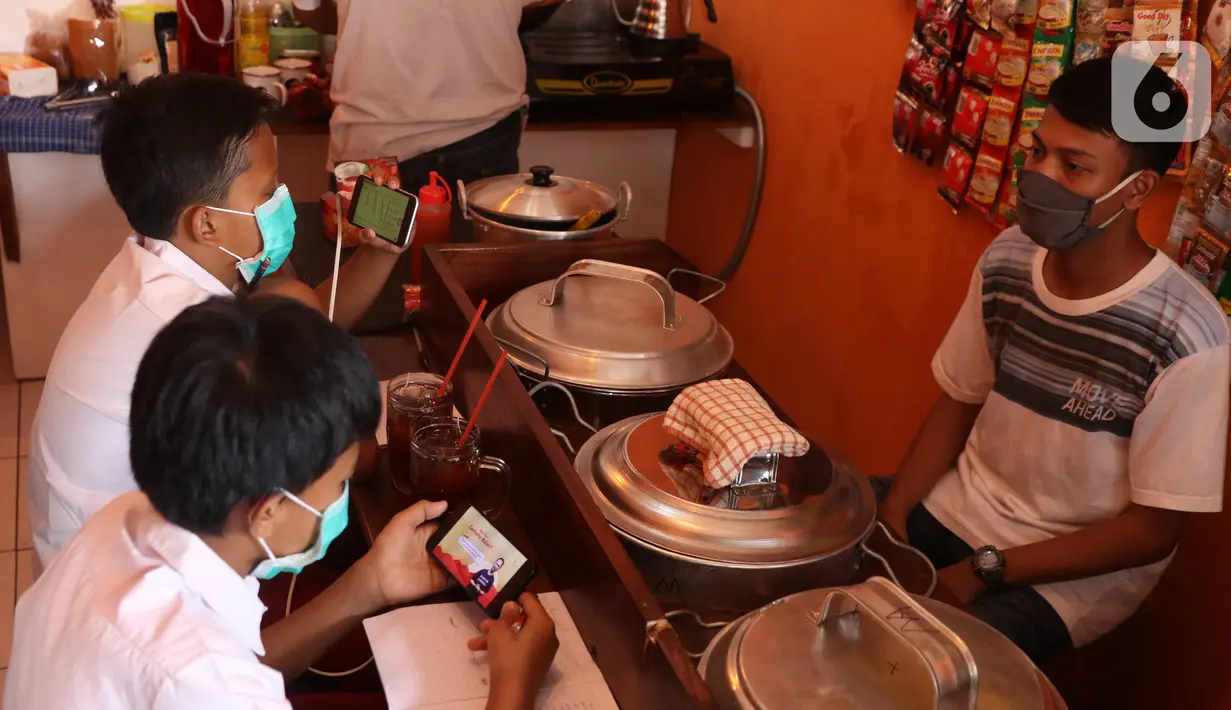 Sejumlah siswa sekolah dasar belajar dengan menggunakan wifi gratis yang disediakan oleh warkop Rizki, di Pondok Aren, Tangerang Selatan, Rabu (29/7/2020). Wifi gratis disediakan untuk membantu anak anak sekitar yang tidak memiliki jaringan internet dan smartphone. (Liputan6.com/Angga Yuniar)