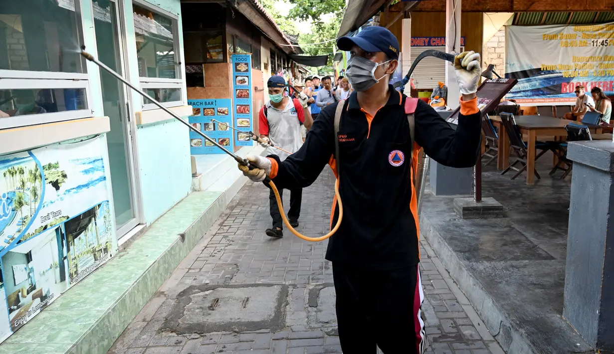 Seorang petugas kesehatan menyemprotkan disinfektan di kawasan wisata di Sanur, Bali, Senin (16/3/2020). Penyemprotan dilakukan sebagai salah satu langkah untuk mengantisipasi potensi penyebaran virus Corona COVID-19 di kawasan pariwisata tersebut. (SONNY TUMBELAKA/AFP)