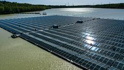Pemandangan dari udara menunjukkan Para pekerja merakit panel surya di pembangkit listrik fotovoltaik terapung di danau Silbersee di Haltern, Jerman barat (22/4/2022). Taman surya terapung ini akan menghasilkan hampir tiga juta kilowatt jam listrik per tahun. (AFP/Ina Fassbender)