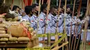 Polisi memegang obor untuk membakar tumpukan ganja sitaan saat upacara di Polda Aceh, Banda Aceh, Aceh, Rabu (23/9/2020). Sebanyak 372,6 kilogram ganja dan 80,2 kilogram sabu serta 27.400 pil ekstasi hasil sitaan polisi dimusnahkan dalam acara tersebut. (CHAIDEER MAHYUDDIN/AFP)