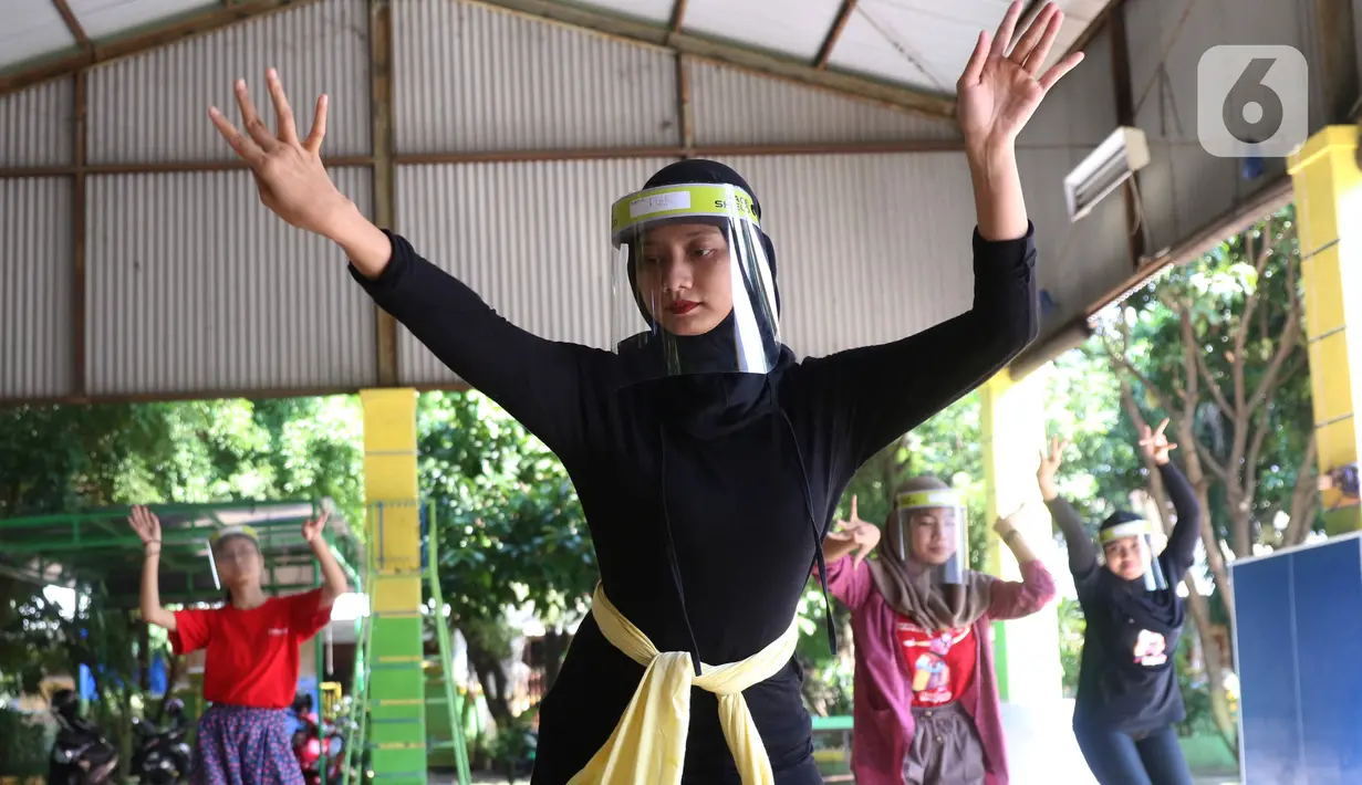 Penari tradisional dari Sanggar Eschoda melakukan latihan menggunakan masker dan pelindung wajah di Kota Tangerang, Jumat (12/6/2020). Para penari itu menerapkan protokol kesehatan jelang new normal atau tatanan hidup normal, sekaligus sebagai upaya pencegahan Covid-19. (Liputan6.com/Angga Yuniar)