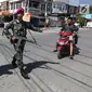 Prajurit Marinir TNI AL membantu warga menyeberangi jalan di perempatan lampu merah kota Palu pascagempa dan tsunami di Palu, Sulawesi Tengah, Jumat (5/10). Selain berjaga di jalan, mereka juga berjaga di beberapa ruko di Palu. (Liputan6.com/Fery Pradolo)