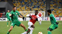 Aksi penyerang muda Arsenal, Eddie Nketiah melewati dua pemain Vorskla pada laga lanjutan Grup E Liga Europa yang berlangsung stadion NSK Olimpiyskiy, Kyiv, Jumat (30/11). Arsenal menang atas Vorskla 3-0. (AFP/Sergei Supinsky)