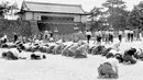 Warga berlutut saat Kaisar Hirohito mengumumkan lewat radio bahwa Jepang telah dikalahkan dalam Perang Dunia II di depan Istana Kekaisaran, Tokyo, Jepang, 15 Agustus 1945. Tanggal 2 September 2020 menjadi peringatan 75 tahun penyerahan resmi Jepang kepada Amerika Serikat.  (Kyodo New via AP, File)