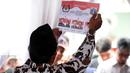 Petugas KPPS menunjukkan keabsahan surat suara Pilkada DKI Jakarta di TPS 027 Kebagusan, Jakarta, Rabu (15/2). Ahok-Djarot unggul dengan 254 suara sementara Anies-Sandi 207 serta AHY-Sylvi 85. (Liputan6.com/Helmi Fithriansyah)