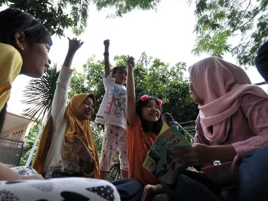 Antusiasme anak-anak mengikuti kuis saat program Literasi Kejujuran di TBM Saung Manggar, Jakarta, Minggu (24/3). Literasi Kejujuran merupakan program yang diinisiasi Suku Dinas Perpustakaan dan Kearsipan Jakarta Timur awal 2019 yang tersebar di taman-taman. (merdeka.com/Iqbal S. Nugroho)