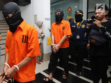 Tersangka kasus penyebaran ujaran bernada kebencian lewat internet digiring polisi usai rilis di Jakarta, Rabu (23/8). Tiga tersangka masuk dalam satu kelompok. (Liputan6.com/Helmi Fithriansyah)