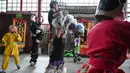 Dengan mengenakan celana panjang berpayet berbulu dan atasan hitam, Lin Xinmeng menjadi bagian dari pemain dalam tarian barongsai. (Jade GAO/AFP)