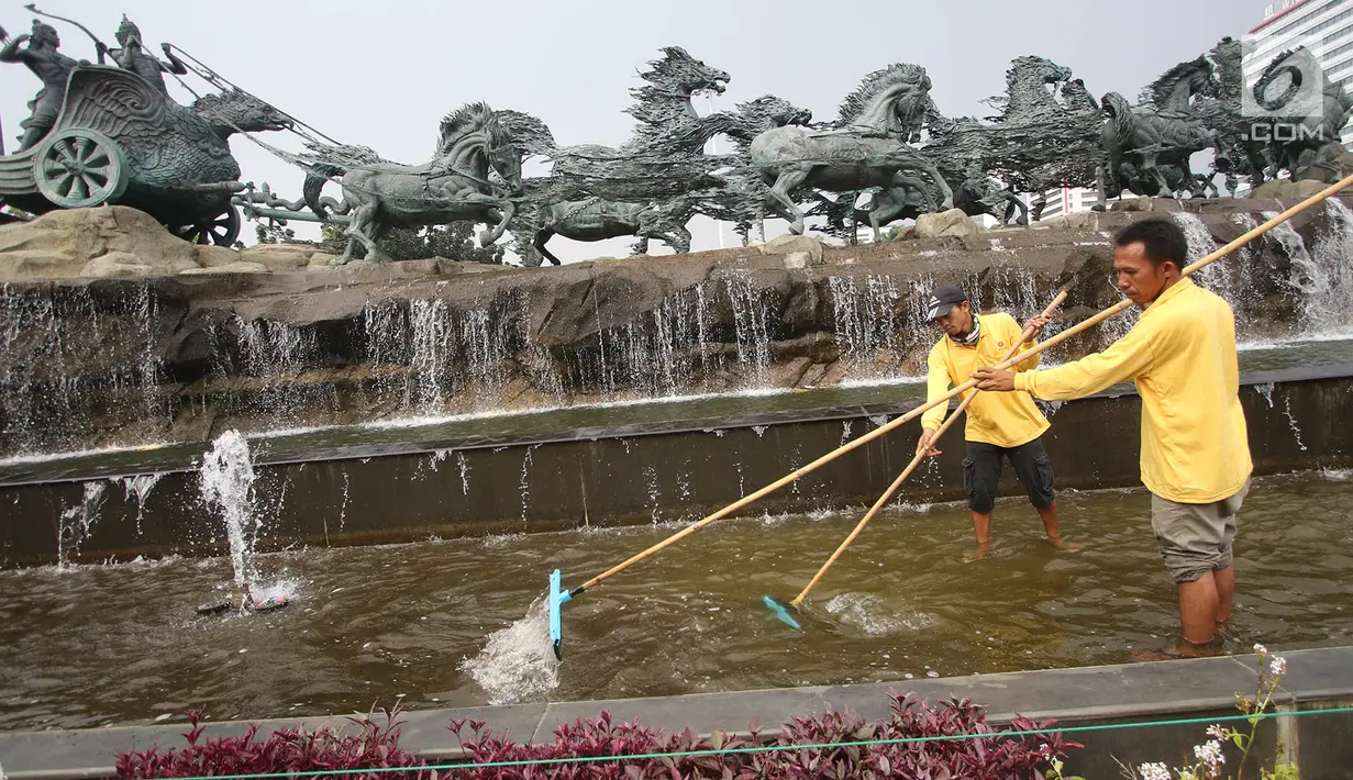 Petugas membersihkan kolam di sekitar Patung Kuda Arjuna Wiwaha, Jakarta, Selasa (15/8). Pembersihan kolam serta penataan bunga dilakukan dalam rangka peringatan hari kemerdekaan RI pada 17 Agustus mendatang. (Liputan6.com/Immanuel Antonius)