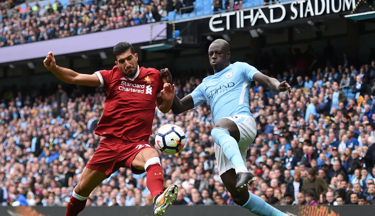 Gelandang Liverpool, Emre Can, berebut bola dengan bek Manchester City, Benjamin Mendy, pada laga Premier League di Stadion Ettihad, Manchester, Sabtu (9/9/2017). City menang 5-0 atas Liverpool. (AFP/Oli Scarff)