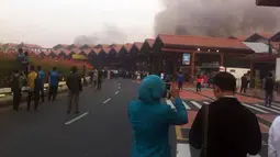 Tampak seorang mengabadikan gambar kebakaran di Terminal 2E di Bandara Soekarno Hatta, Jakarta, Minggu (5/7/2015). Hingga kini penyebab terjadinya kebakaran tersebut belum diketahui dan masih dalam penyelidikan. (Twitter@baabullah)