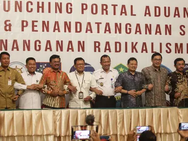 Menkominfo Johnny G. Plate (keempat kiri) bersama sebelas Kementerian dan lembaga negara  usai penandatangan kerja sama pembuatan portal aduan untuk aparatur sipil negara (ASN), Jakarta, Selasa (12/11/2019). Portal ini bisa melaporkan ASN yang diduga terpapar radikalisme (Liputan6.com/Faizal Fanani)