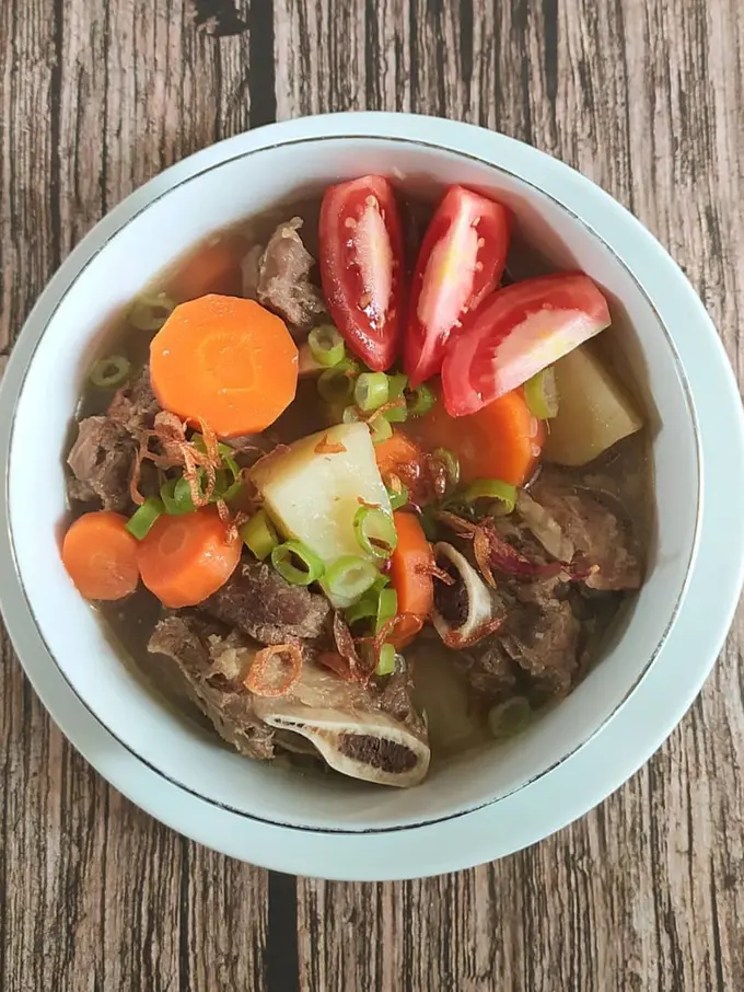 Semangkuk sop iga sapi dengan tomat dan wortel