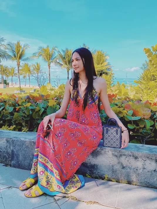Maxi dress berpotongan kerah halter dengan kombinasi warna cerah khas gaun pantai. [@miktambayong]