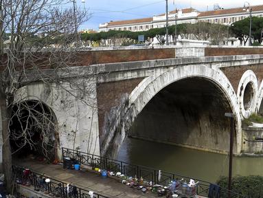 Sejumlah barang milik tunawisma terlihat di kawasan permukiman kumuh bawah jembatan di Sungai Tiber, Roma, Italia (13/4). Para tunawisma menggunakan kayu, karton, hingga terpal plastik untuk membuat tenda sebagai tempat tinggalnya. (REUTERS / Max Rossi)