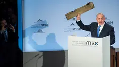 Perdana Menteri Israel Benjamin Netanyahu menunjukkan benda yang diduga potongan pesawat tak berawak Iran yang ditembak jatuh di wilayah Israel saat pidato dalam Konferensi Keamanan Munich (18/2). (AFP/ MSC Munich Security Conference / Lennart Preiss)