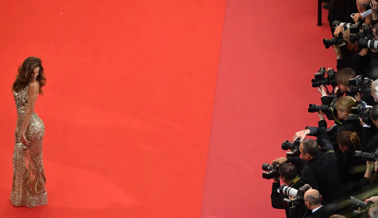 Izabel Goulart berpose di karpet merah saat menghadiri pemutaran film "Burning" selama Festival Film Cannes ke-71 di Prancis selatan (16/5). Model asal Brasil ini tampil cantik dan seksi dengan gaun gold transparan. (AFP Photo/Loic Venance)