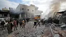 Anggota Syrian Civil Defence atau White Helmets memadamkan api di lokasi serangan udara rezim di Idlib, Suriah, Rabu (15/1/2020). Serangan udara yang dilancarkan pasukan pemerintah menghantam pasar sayur-mayur dan toko-toko reparasi di Idlib. (Omar HAJ KADOUR/AFP)