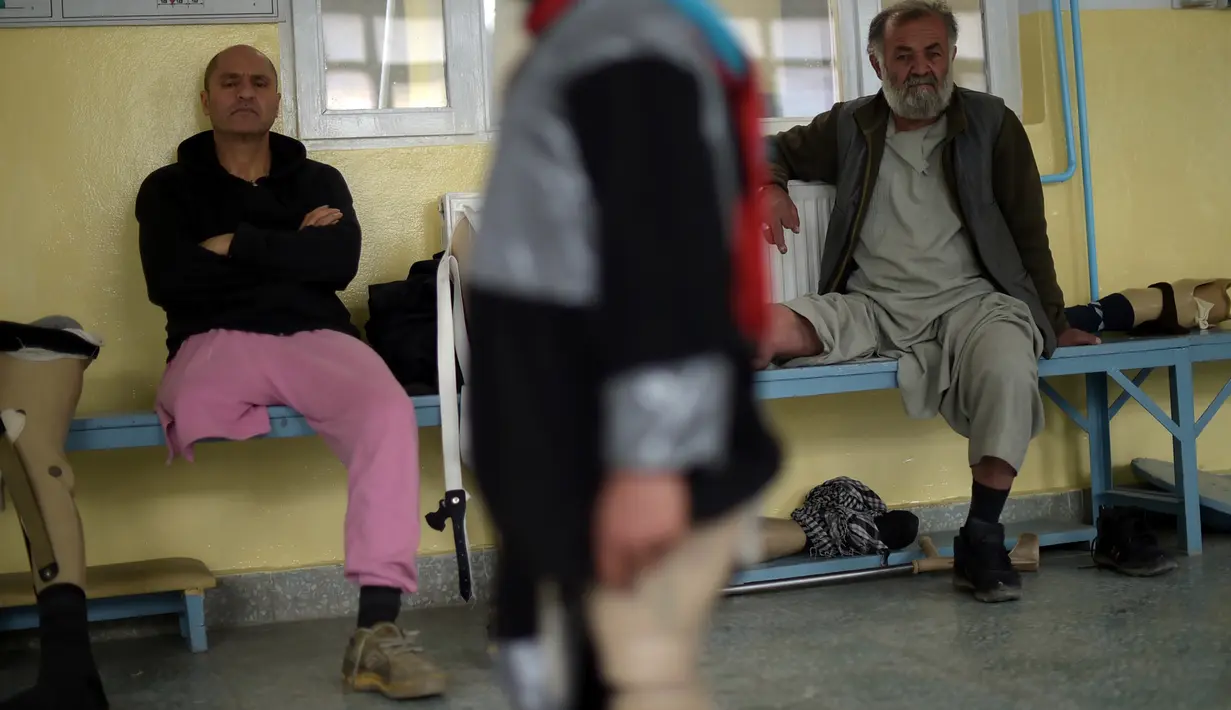 Dua orang pria yang kakinya diamputasi sedang bersantai di pusat ortopedik Komite Internasional Palang Merah (ICRC), rumah sakit bagi korban perang dan yang diamputasi, di Kabul, Minggu (3/4).  (SHAH Marai/AFP)