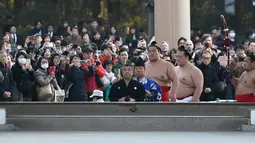 Juara Grand Sumo, Kisenosato (kedua depan) memasuki lapangan untuk melakukan upacara mengentakkan kaki menyambut tahun baru di Kuil Meiji, Tokyo, 8 Januari 2019. Ritual penyambutan tahun baru itu melibatkan tiga juara pegulat sumo (Toshifumi KITAMURA/AFP)
