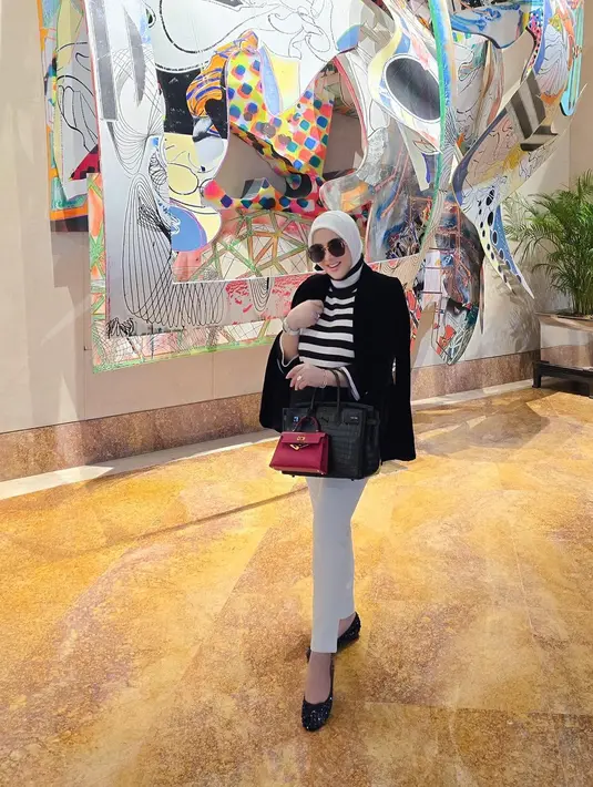 Foto ini diambil dari jarak yang lebih jauh untuk menunjukkan karya seni yang menjadi background-nya. Istri Reino Barack itu masih menutup bagian perutnya. (foto: Instagram/ princessyahrini)