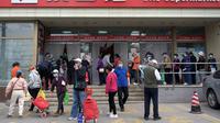 Orang-orang mengantre di luar supermarket untuk membeli persediaan makanan di Beijing pada 25 April 2022. Kekhawatiran penguncian Covid memicu pembelian panik dan antrean panjang untuk pengujian massal di Beijing pada 25 April ketika otoritas China bergegas untuk membasmi wabah di ibu kota. (AFP/Noel Celis)
