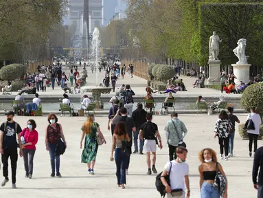 Orang-orang memakai masker wajah saat mereka berjalan di jalur taman Tuileries, Paris, Prancis, Kamis (1/4/2021). Prancis bersiap melakukan lockdown setelah pemerintah menemukan adanya lonjakan kasus COVID-19. (AP Photo/Thibault Camus)