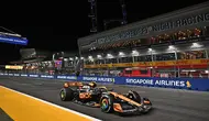 Pembalap tim McLaren, Lando Norris memacu mobilnya saat melintasi tribun dalam balapan F1 GP Singapura 2023 di Marina Bay Street Circuit, Singapura, Minggu (17/9/2023) malam WIB. (AFP/Lillian Suwanrumpha)
