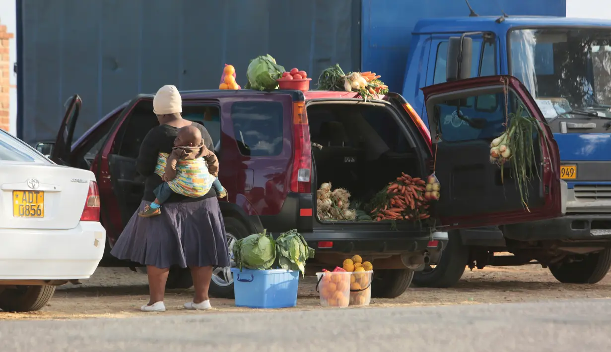 Orang-orang menjual berbagai barang di dalam bagasi mobil di sisi jalan yang sibuk di Harare, 23 Juni 2020. Mobil menjadi pasar bergerak di mana penduduk Zimbabwe menjual barang dagangan dari kendaraan untuk mengatasi kesulitan ekonomi yang disebabkan Covid-19. (AP Photo/Tsvangirayi Mukwazhi)