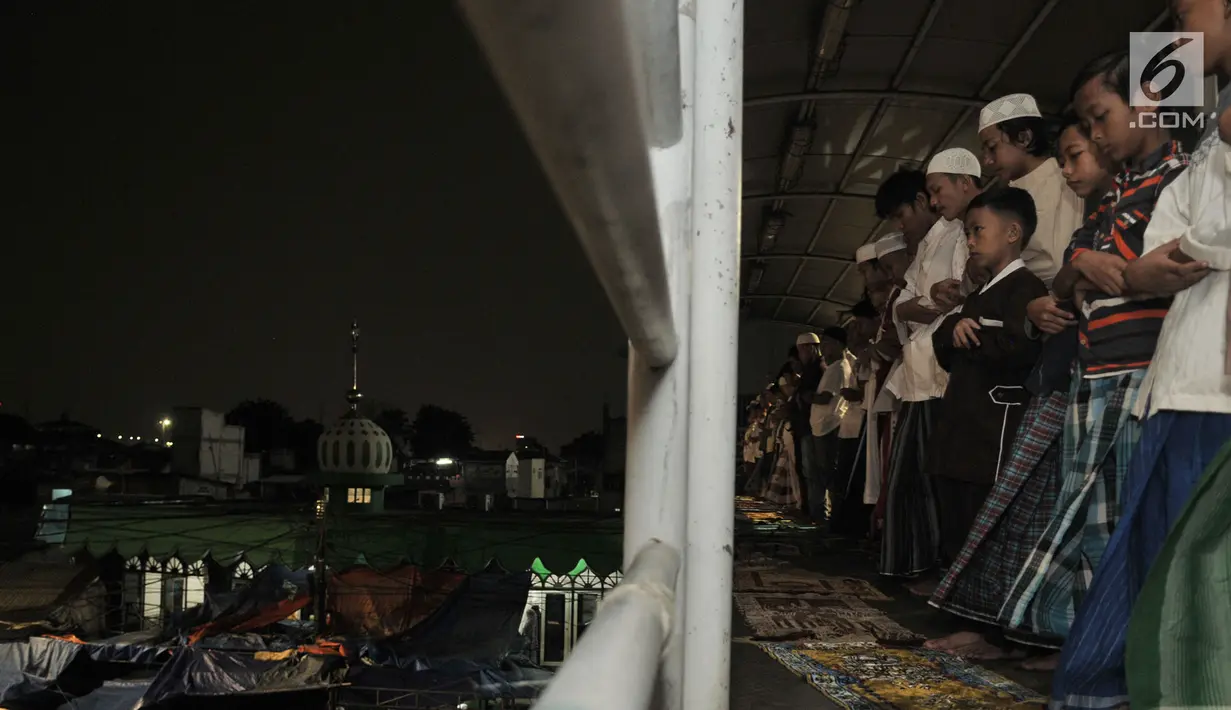 Sejumlah warga melaksanakan salat tarawih di atas Jembatan Penyebrangan Orang (JPO) Mushola Mifhtaul Jannah di Kawasan Pasar Gembrong, Jakarta, 5 Mei 2019. JPO yang biasa digunakan untuk akses menyeberang mendadak jadi area ibadah salat tarawih pada Ramadan 1440 H. (merdeka.com/Iqbal S. Nugroho)
