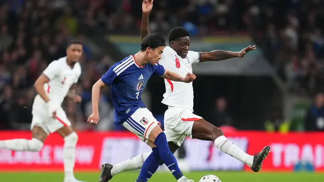 Winger Timnas Jepang Kaoru Mitoma diadang gelandang Timnas Inggris Kobbie Mainoo di laga uji coba di Stadion Wembley, Rabu (01/4/2026) dini hari WIB.