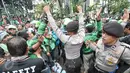 Petugas kepolisian mencoba menenangkan massa driver Gojek yang berunjuk rasa di kantor PT Gojek Indonesia, Kemang, Jakarta, Senin (3/10). Aksi dorong-dorongan driver Gojek dengan polisi sempat mewarnai unjuk rasa tersebut. (Liputan6.com/Yoppy Renato)